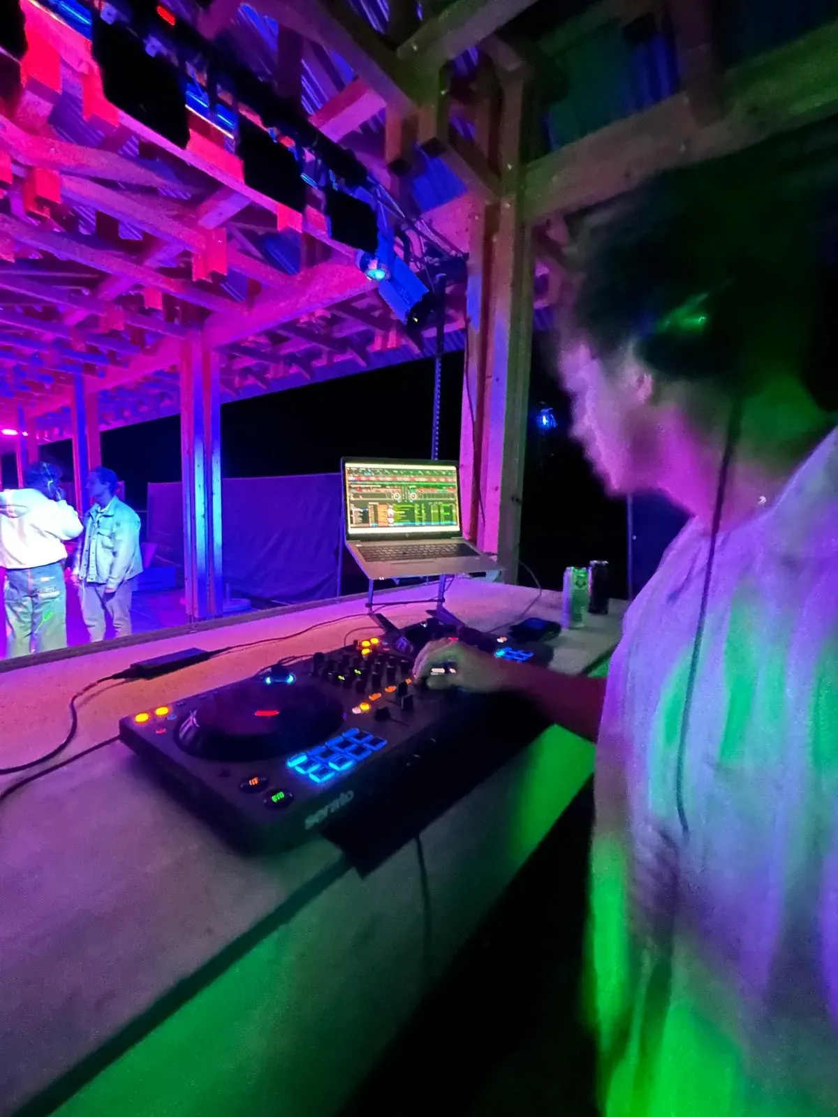 Ben am DJ-Controller unter einem bunt beleuchteten Holzdach